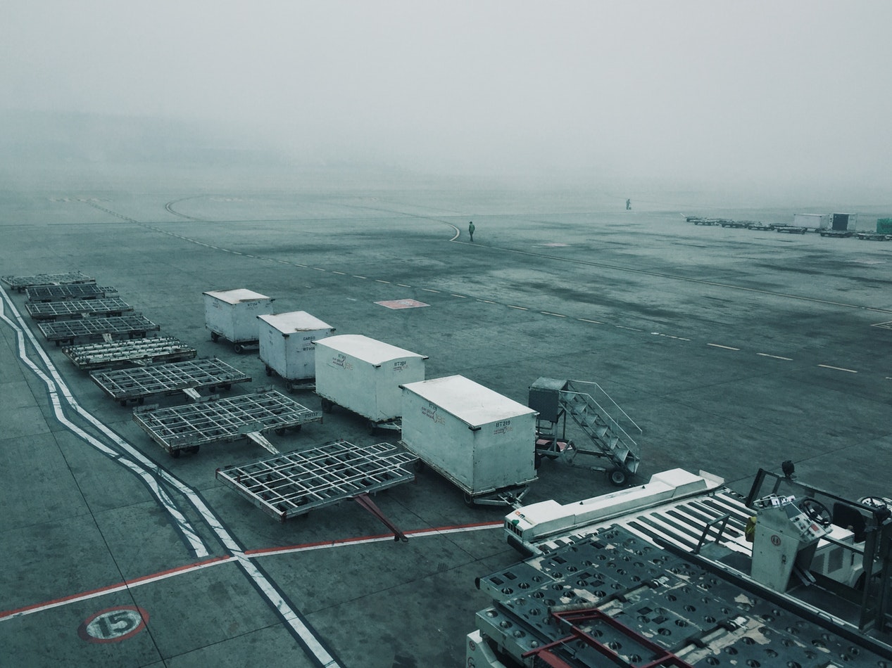 Ground crew inspecting vehicles and equipment near an airport tarmac as part of paperless asset management