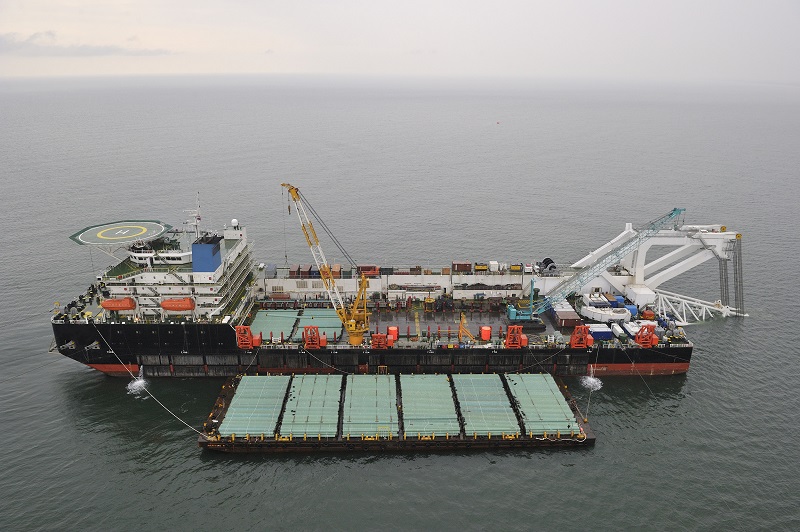 Marine inspector using a tablet to conduct a digital inspection of a crane barge at a port facility