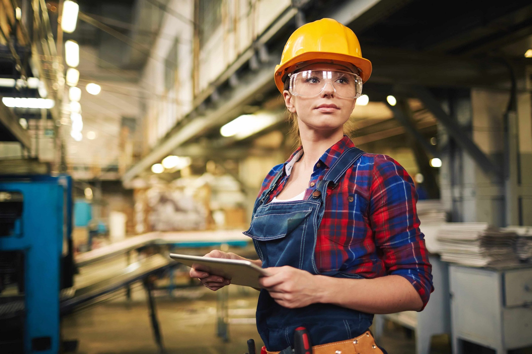 Quality assurance manager in a manufacturing facility reviewing inspection data on a tablet device