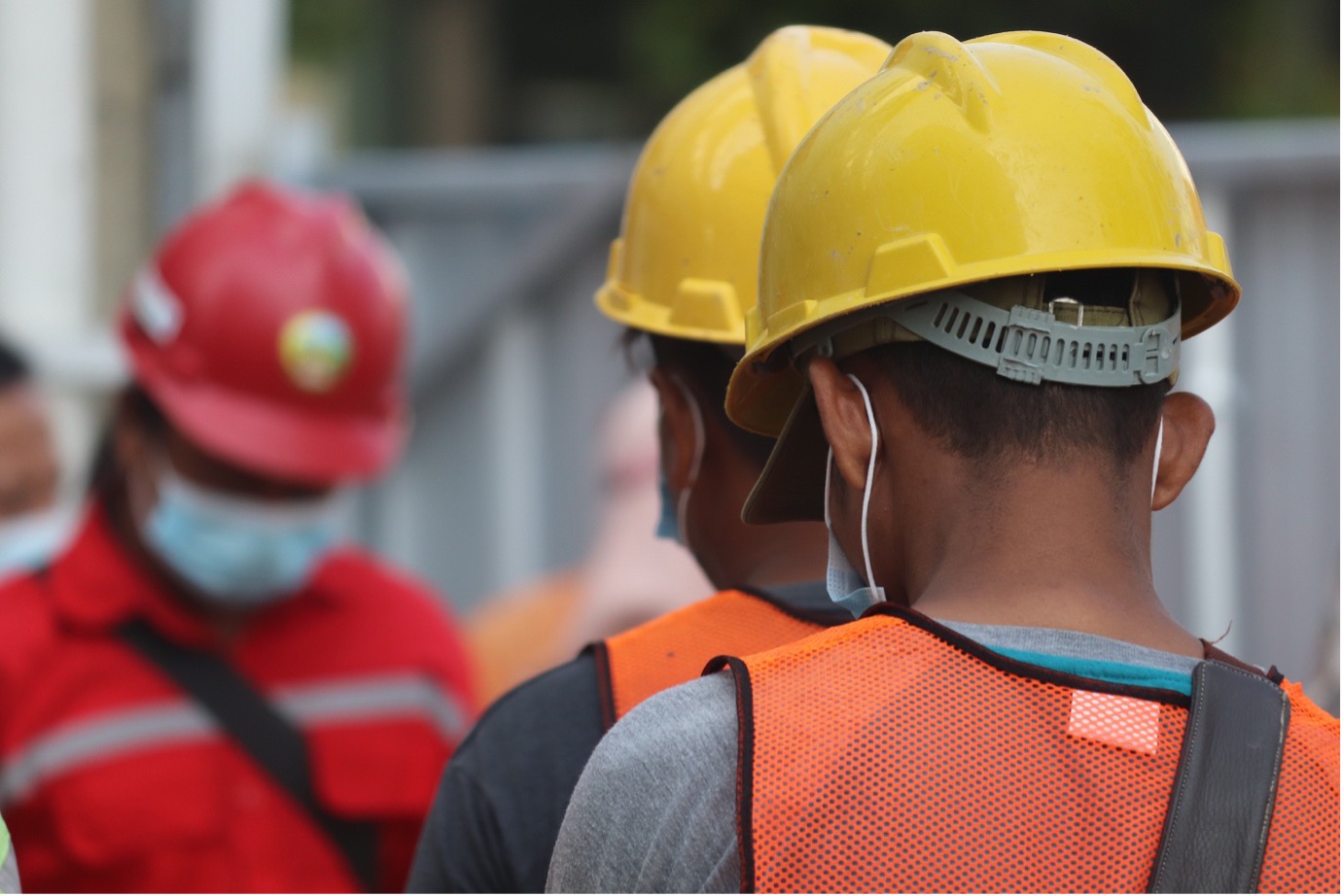 Field worker using a tablet to complete a digital compliance inspection on a construction site